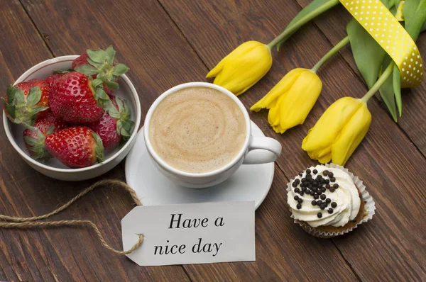 Cup of coffee, tulips, croissant, strawberries and Have a nice day massage on wooden background