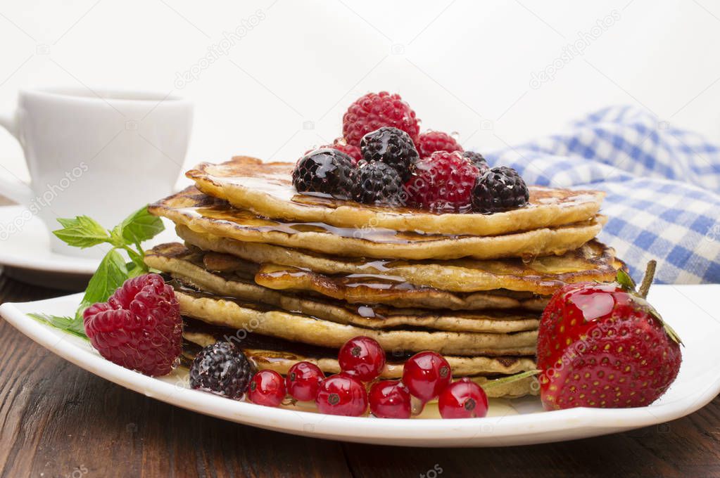 Delicious pancakes with berries and maple syrup. Top
