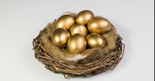 Gouden eieren in nest. Gouden eieren in close-up. Camerarotatie — Stockvideo