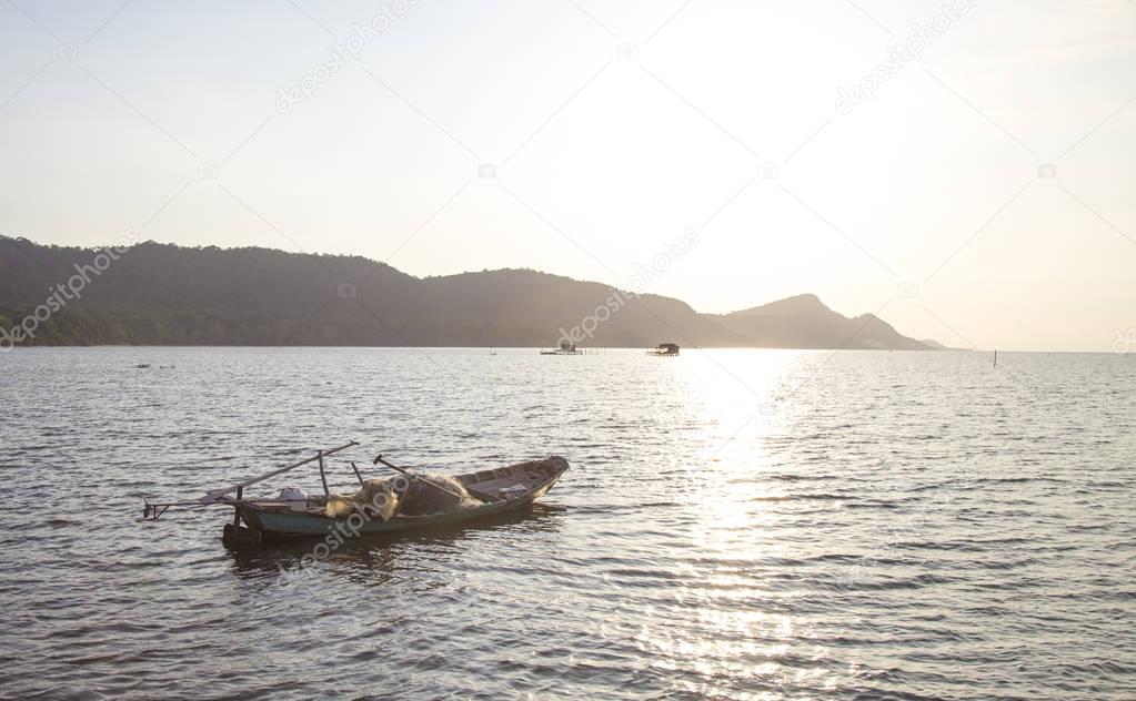 fishing boat sailing at sunset