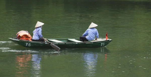 Mulheres vietnamitas remando um barco — Fotografia de Stock
