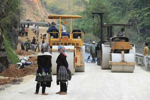 Mulheres olhando para niveladores de estrada de trabalho — Fotografia de Stock