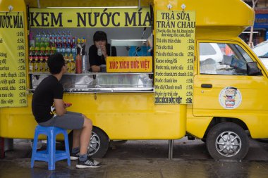 Hanoi, Vietnam - 22 Kasım 2015: şeker kamışı ve taze tropikal meyve suyu Hanoi capital bir sokakta hizmet veren Vietnamca kız. Hanoi sokak gıda ve içecekler için iyi bilinen bir yer.