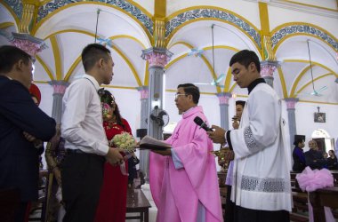 Ninh Binh, Vietnam - Vietnamlı papaz kilisede toplu bir düğün töreni düzenliyor.