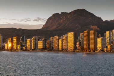 Benidorm, İspanya - 24 Kasım 2019: Benidorm 'da gün batımı ve İspanya' da Costa Blanca 'da Puig Campana adlı dağ.