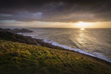 A Winter sunrise over the Mumbles lighthouse and the South Gower headland, Swansea, UK