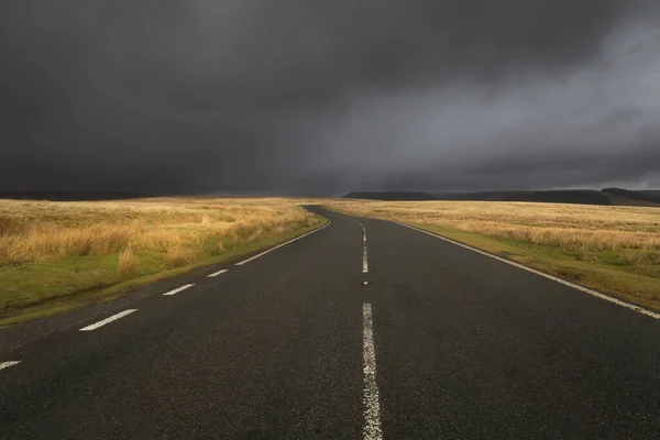 The road to PenyfanChangeable weather on the A4059 from the village of Penderyn heading towards Penyfan in the Brecon Beacons, South Wales UK