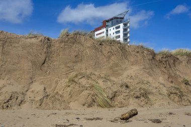 Editör SwanSEA, İngiltere - 16 Mart 2020: Eroded kum tepecikleri Galler 'in Swansea Körfezi' nde olağandışı yüksek gelgitlerle sürüklendi