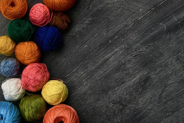 Bolas coloridas de hilo sobre fondo de madera de pizarra . — Foto de Stock