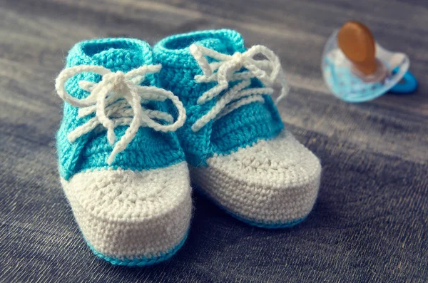 Photo tonique de bleu crochet bottines pour enfants avec petit mamelon sur fond en bois . — Photo