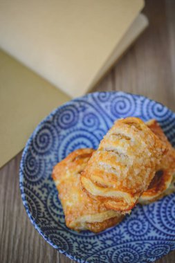 Ahşap arka plan üzerinde boş kitap ile taze puf hamur işleri