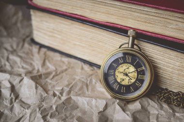 Vintage tonda buruşuk kağıt eski kitapları ile cep saati