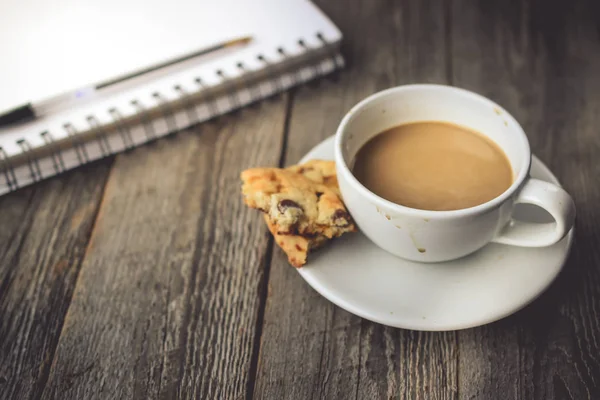 Książki i pliki cookie z gorącej kawy na brudne szklanki na tle drewna — Zdjęcie stockowe