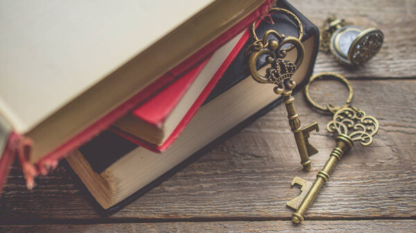 Pocket watch and Old vintage key on  stack of old book with copy