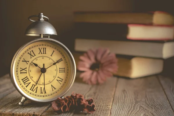 Roman Numeral in Vintage Alarm Clock and Stack of Book Background — Stock Photo, Image