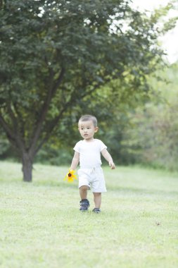 Bir parkta oynayan sevimli Çinli bebek çocuk