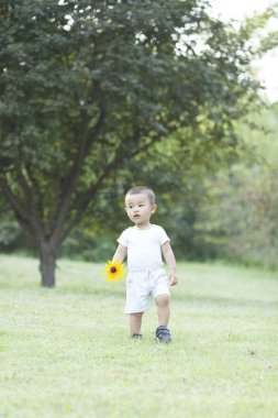 Bir parkta oynayan sevimli Çinli bebek çocuk