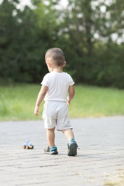 Şirin Çinli bebek çocuk oyuncak araba bir parkta oynarken