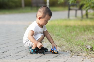 Şirin Çinli bebek çocuk oyuncak araba bir parkta oynarken