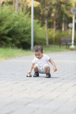 Şirin Çinli bebek çocuk oyuncak araba bir parkta oynarken