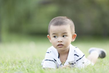 Çayır üzerinde yalan mutlu Çinli bebek çocuk