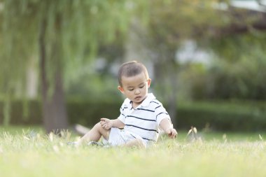 Çayır üzerinde oynarken mutlu Çinli bebek çocuk