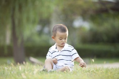 Çayır üzerinde oynarken mutlu Çinli bebek çocuk