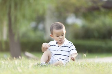 Çayır üzerinde oynarken mutlu Çinli bebek çocuk