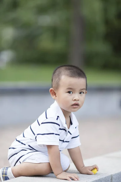 Gelukkig Chinese jongetje spelen in een park — Stockfoto