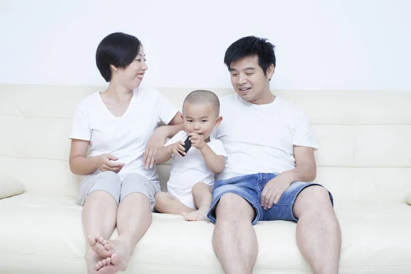 Glückliche chinesische Familie sitzt im Sofa — Stockfoto
