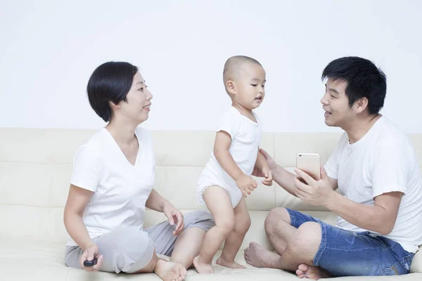Glückliche chinesische Familie spielt auf Sofa — Stockfoto