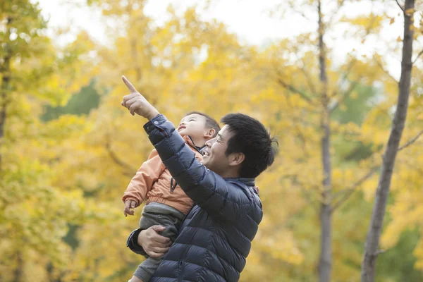 Pai e filho verdadeiros felizes apontando para longe — Fotografia de Stock