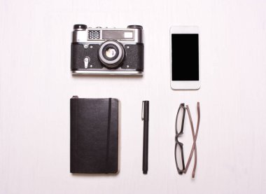 halkalar, gözlük, fotoğraf makinesi, telefon, defter beyaz bir arka plan
