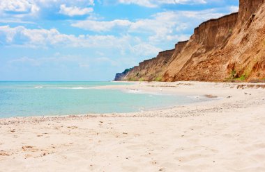 Mavi gökyüzü, turkuaz deniz, kumsal ve dağlar