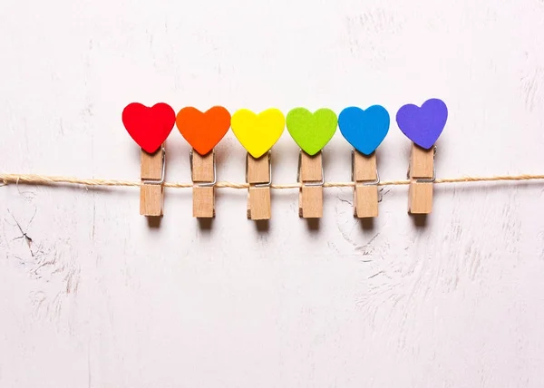 Wooden hearts of rainbow colors on clothespins . The symbol of L — Stock Photo, Image