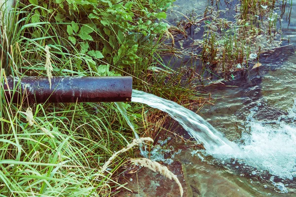 Kanalizace teče do jezera, do řeky. znečištění životního prostředí. — Stock fotografie