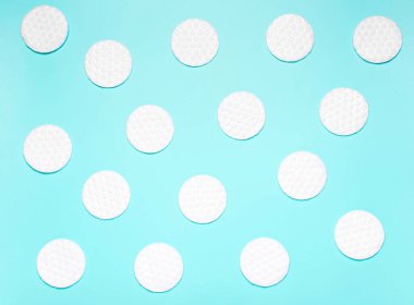 Mavi arka planda beyaz pamuk diskler. Temizlik, makyaj, vücut bakımı kavramı. Üst manzara, düz
