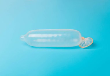 Mavi arka planda prezervatif. Güvenli seks kavramı, cinsel yolla bulaşan hastalıkların enfeksiyonunu durdurmak, STD, AIDS. 