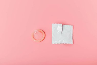 Pembe arka planda prezervatif. Güvenli seks kavramı, cinsel yolla bulaşan hastalıkların, cinsel yolla bulaşan hastalıkların, AIDS 'in, istenmeyen hamileliğin durdurulması, kürtaja alternatif olması.