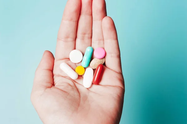 Tabletten Der Hand Auf Blauem Hintergrund Das Konzept Von Gesundheit lizenzfreie Stockbilder