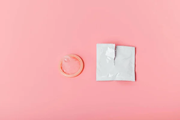 ピンクの背景にコンドーム 安全なセックスの概念は 性感染症 性感染症 性感染症 エイズ 不要な妊娠 中絶への代替の送信を停止します ストック画像