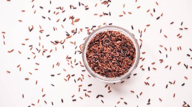 Üstten Görünüm dağınık kahverengi pirinç düz beyaz arka plan üzerinde yatıyordu