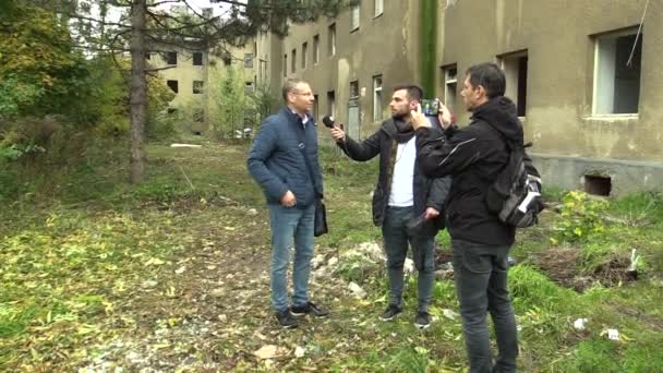 PREROV, CZECH REPUBLIC, OCTOBER 29, 2017: Ghetto poor in Prerov, street with abandoned former Gypsy ghetto, reporter and cameraman filming a smartphone mobile report television with a microphone — Stock Video
