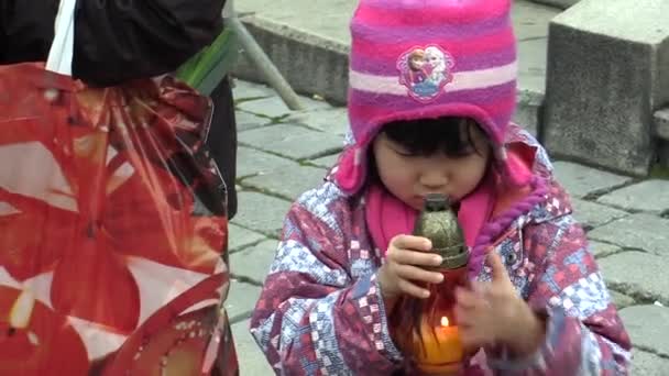 OLOMOUC, CZECH REPUBLIC, DECEMBER 24, 2017: Asian girl holding a lantern with a candle in his hand, the Christians the Bethlehem light — Stock Video