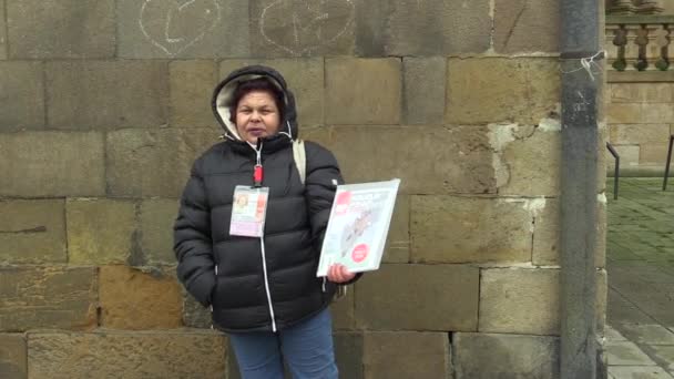 OLOMOUC, REPÚBLICA CHECA, 24 DE ENERO DE 2017: Una mujer vendiendo una revista Novy Prostor o Street News en la calle, ayudando a las personas sin hogar y a las personas en situación de pobreza en la angustia social, vendida por primera vez en los Estados Unidos — Vídeos de Stock