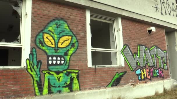 OLOMOUC, CZECH REPUBLIC, JANUARY 18, 2018: Графитти зеленого пришельца на заброшенном здании с надписью fuck, разбитые окна. Очень провокационный, подлинный страх, депрессия — стоковое видео