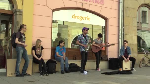 OLOMOUC, REPÚBLICA CHECA, 12 DE ABRIL DE 2018: Grupo de banda de música callejera tocando en saxofón, guitarra y tambor, rogando dinero en los buskers callejeros de la ciudad, República Checa, Eurore — Vídeo de stock