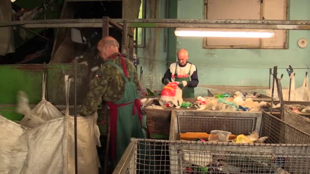 Olomouc, Tjeckien, 25 April 2018: raden för industriella sortering av olika typer av plast avfall. Fattiga och människor jobb. De sorterar på blå, grön och transparent Pet-flaskor, återvinning — Stockvideo