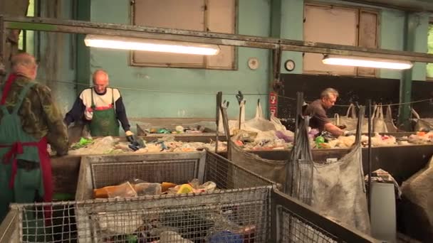 OLOMOUC, RÉPUBLIQUE TCHÈQUE, 25 AVRIL 2018 : Ligne de tri industriel de différents types de déchets plastiques. Les pauvres et les gens travaillent. Ils trient sur des bouteilles en PET bleu, vert et transparent, recyclage — Video