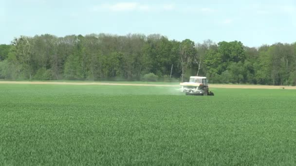 OLOMOUC, REPÚBLICA CHECA, 27 DE ABRIL DE 2018: Tractor con esparcidor de fertilizante grande moderno de remolque. Fertilizantes NPK Nitrógeno, fósforo y potasio para la fertilización de campos de trigo . — Vídeo de stock